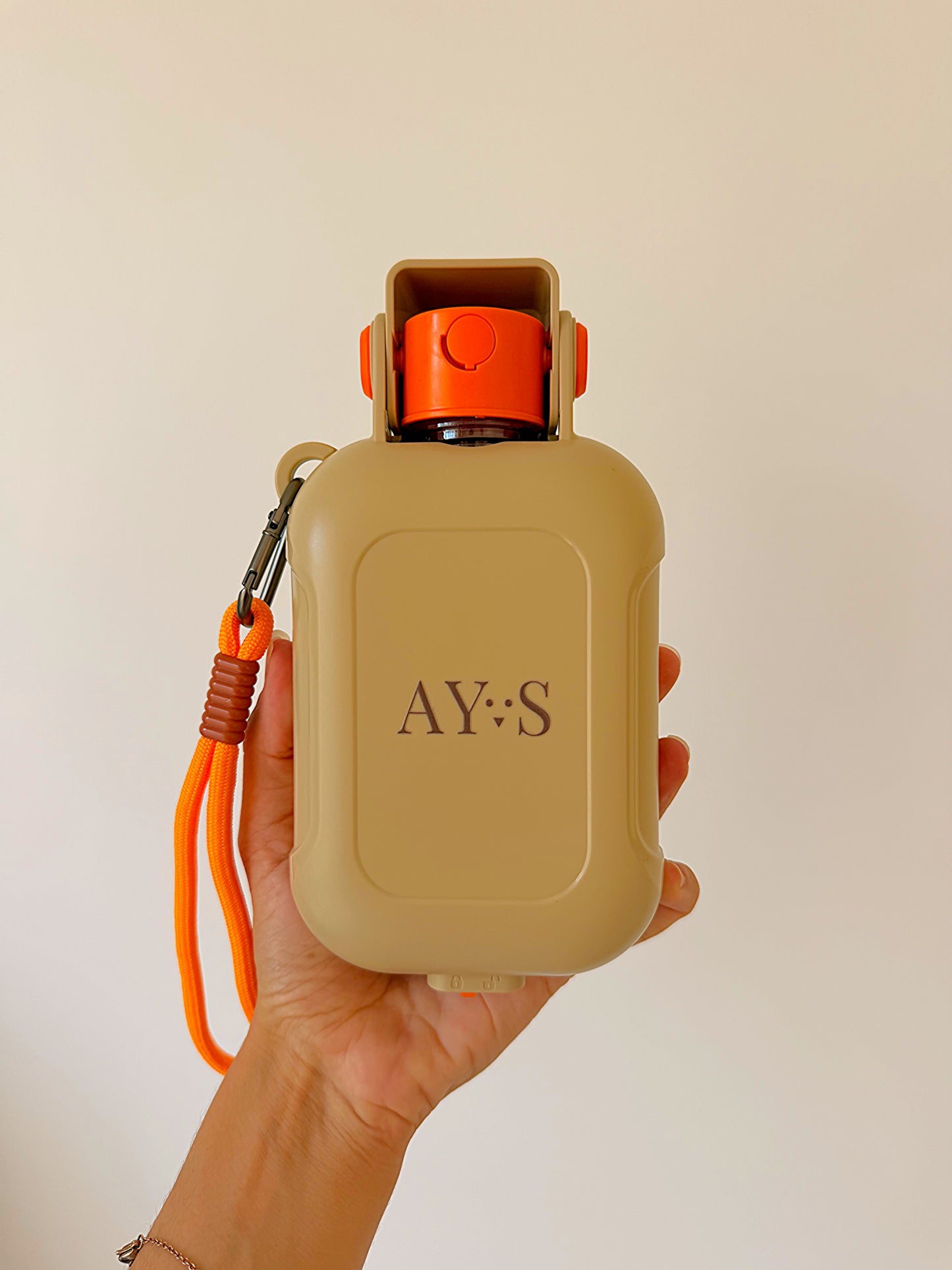 Gourde portable pour chien AYOS Club tenue en main, format compact avec gamelle intégrée et système anti-fuite.