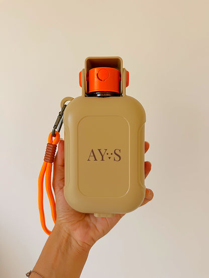 Gourde portable pour chien AYOS Club tenue en main, format compact avec gamelle intégrée et système anti-fuite.