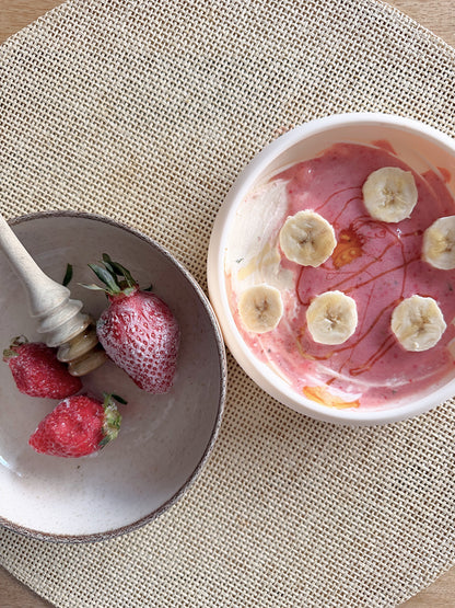 Tapis de léchage Nuage garni de yaourt, fraises, banane et miel, présenté avec des fraises fraîches.