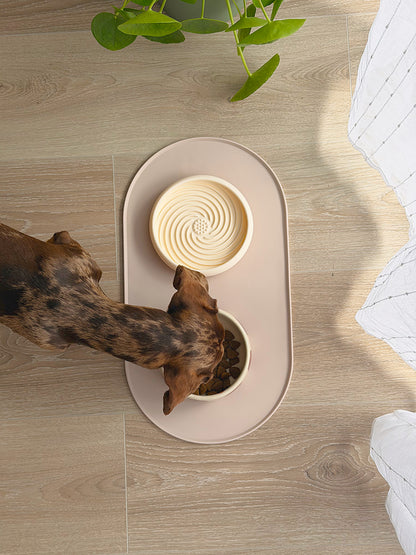 Tapis de gamelle antidérapant AYOS en silicone couleur grège utilisé par un chien pendant son repas.